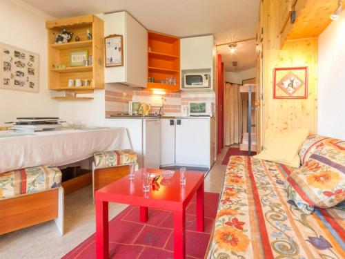 - un salon avec un canapé et une table rouge dans l'établissement Appartement cosy près des pistes avec WIFI gratuit - FR-1-275-145, à Montvalezan