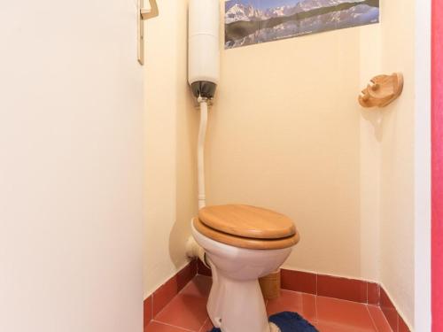 La salle de bains est pourvue de toilettes et d'un siège en bois. dans l'établissement Appartement cosy près des pistes avec WIFI gratuit - FR-1-275-145, à Montvalezan
