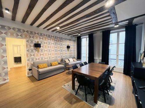 un salon avec une table et un canapé dans l'établissement Urban Flat 108 - Stunning 4 BDR Flat in Paris, à Paris