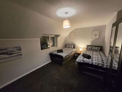 a bedroom with two beds and a chair in it at Shrewsbury Creations in Shrewsbury
