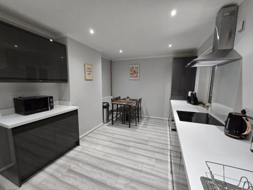 a kitchen with white countertops and a table with chairs at Shrewsbury Creations in Shrewsbury