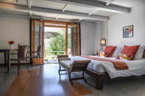 a bedroom with a bed and a desk and a window at Domaine du Val de Sault in Sault-de-Vaucluse