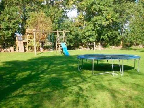 a blue table in the middle of a field with a playground at "Ferienhaus Vadersdorf" Wohnung 2 in Vadersdorf