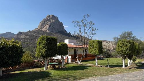 a house in a park with a mountain in the background at Hotel Quinta Mirador Zacualli in Bernal