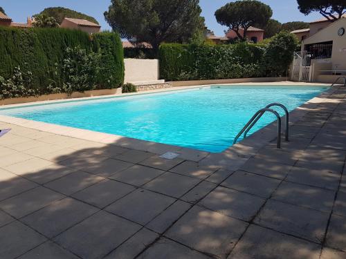 une piscine avec de l'eau bleue dans une cour dans l'établissement Appartement duplex de standing au calme avec piscine, à Fréjus