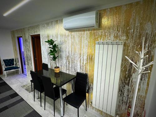 a dining room with a table and chairs against a wall at Apartament cu 2 Dormitoare de lux situat in complex ApartHotel Botosani 1 in Botoşani