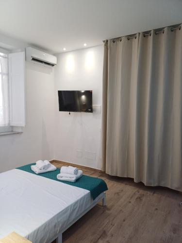 a bedroom with a bed and a tv on the wall at Carruzzata 2 in Bagheria