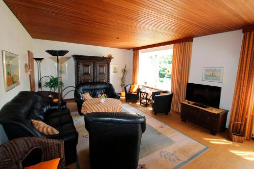a living room with black leather furniture and a flat screen tv at Ferienhof Ralf Becker Nr5 in Westfehmarn