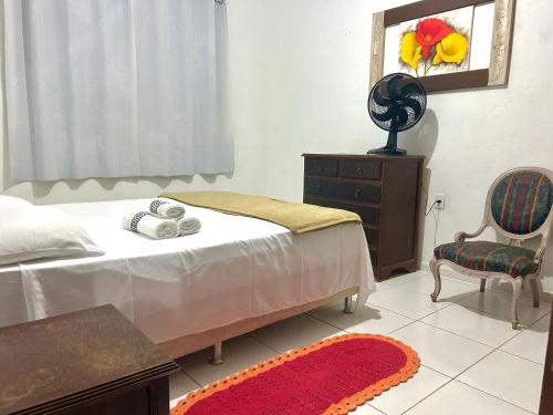 a bedroom with a bed and a dresser and a chair at Apartamento Familiar em Capitólio in Capitólio