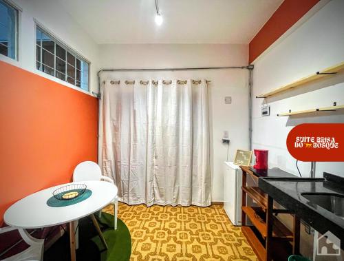 a room with a white table and a curtain at Casa e Suíte Brisa do Bosque in Belém