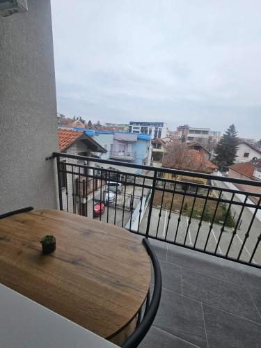 a wooden table on a balcony with a view at Two in Kragujevac