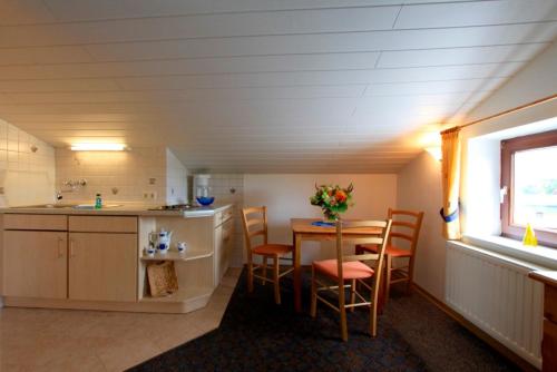eine Küche und ein Esszimmer mit Tisch und Stühlen in der Unterkunft "Ferienhof Alte Mühle" W 1a in Bannesdorf