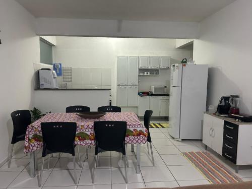a kitchen with a table and chairs and a refrigerator at Apartamento Familiar em Capitólio in Capitólio