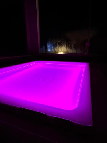 a neon pink tub in a dark room at La Siègià Resort spa in Massa Marittima
