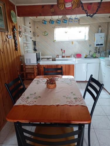 a kitchen with a table and chairs and a kitchen with a table and a kitchen at Cabaña Maggie in Guanaqueros