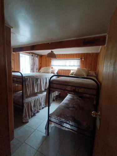 a bedroom with two bunk beds and a window at Cabaña Maggie in Guanaqueros