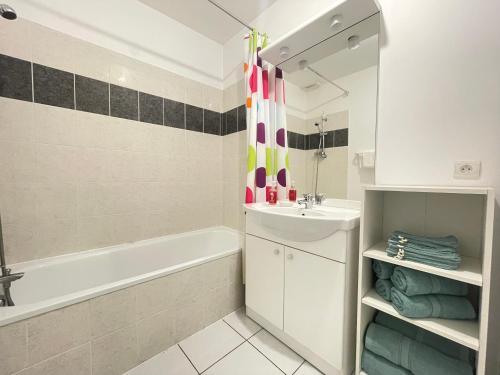 La salle de bains est pourvue d'une baignoire, d'un lavabo et d'une baignoire. dans l'établissement Confort & Balcon,Cœur de Biscarrosse !, à Biscarrosse