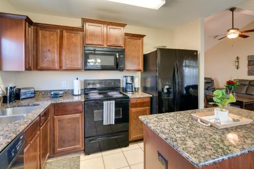 a kitchen with stainless steel appliances and wooden cabinets at Suburban Home in Magnolia with Fenced Yard in Magnolia