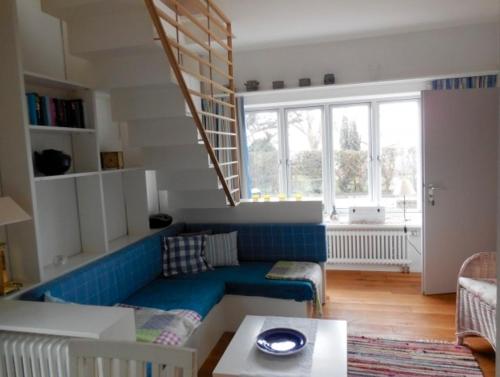 a living room with a blue couch and a window at Ferienhaus Schwille - Loft 2 in Westerbergen