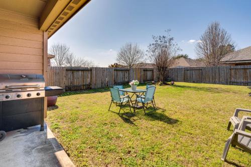 a backyard with a table and chairs and a grill at Suburban Home in Magnolia with Fenced Yard in Magnolia