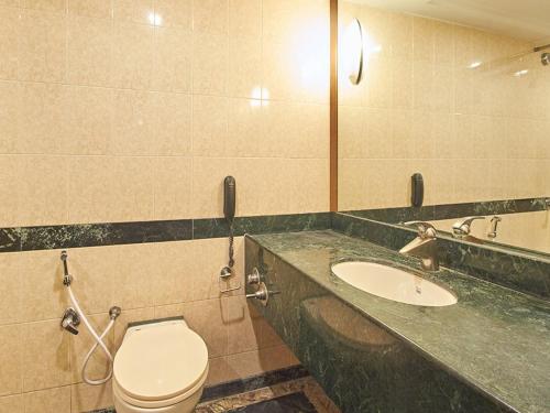 a bathroom with a toilet and a sink at Sarovar Portico Rivera Ahmedabad in Ahmedabad