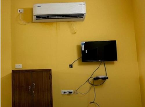 a room with a tv and a air conditioner on a wall at Dream Promenade Beach Side in Puducherry