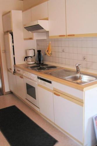 a kitchen with a sink and a stove top oven at Ferienhof Ralf Becker Nr2 in Westfehmarn