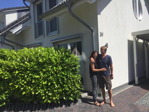 a man and a woman standing in front of a building at Feriendoppelhaushälfte Böttcher in Meeschendorf
