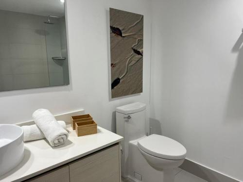 a white bathroom with a toilet and a sink at Apt Miami Beach 1B1B with Kitchen Beach and Mall 2308 in Hallandale Beach