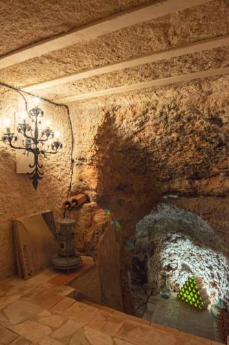 a room with a stone wall and a chandelier at Casa de la Plata in Colmenar de Oreja