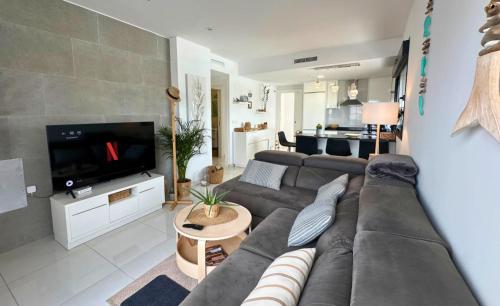 a living room with a couch and a tv at Torremar 81 Exclusivo apartamento con terraza in Torre de la Horadada