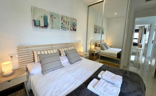 a bedroom with a large bed and a mirror at Torremar 81 Exclusivo apartamento con terraza in Torre de la Horadada