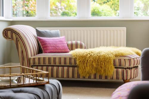 a living room with a couch with a pink pillow at The Kingsway in Ilkley