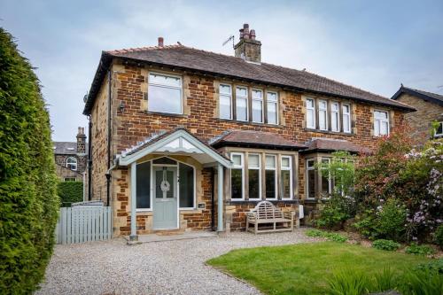 a brick house with a white door and windows at The Kingsway in Ilkley