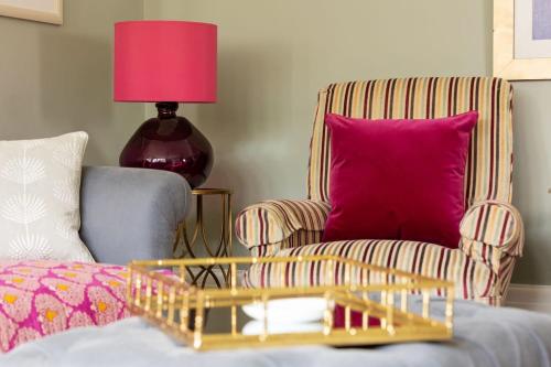 a living room with a chair and a pink pillow at The Kingsway in Ilkley