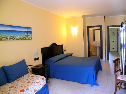Habitación de hotel con cama y silla en B&B Miramare, en Giardini Naxos