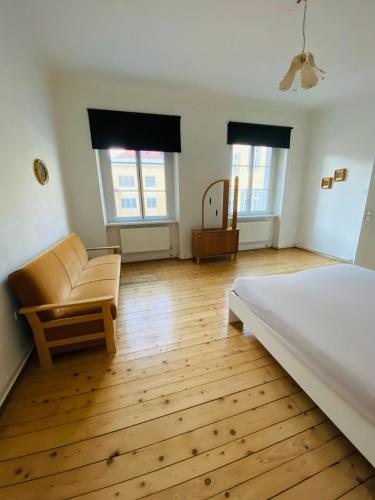 a bedroom with a bed and a couch and windows at Wohnung, 2 Schlafzimmer, Innenhof in Graz
