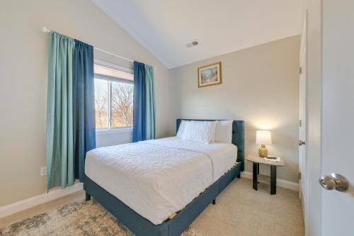 a bedroom with a bed with blue curtains and a window at 6 Mi to PNC Music Pavilion Concord Townhome in Concord