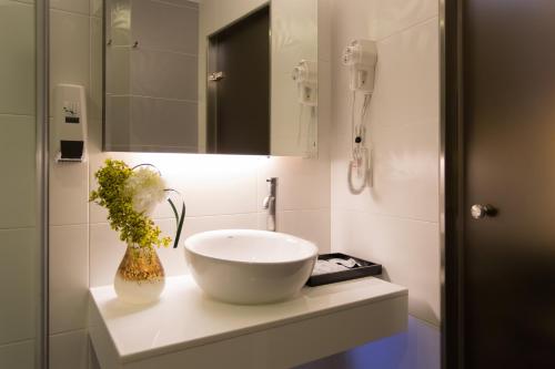 a bathroom with a white sink and a mirror at 麗馨商旅七賢館 in Kaohsiung