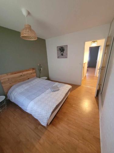 a bedroom with a bed and a wooden floor at Maison, 5 Chambres équipées, tout confort , fibre in Ouzouer-sur-Loire