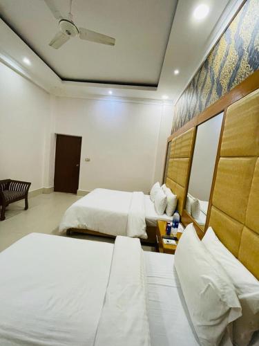 a hotel room with two beds and a mirror at The Lodge Inn in Karachi