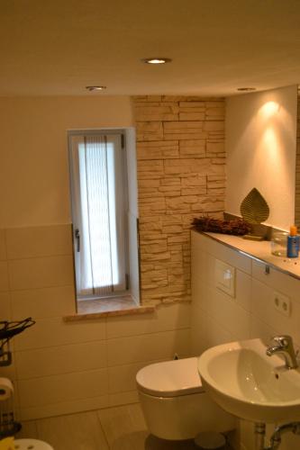 a bathroom with a sink and a toilet and a window at Feriendomizil "Anker" H 2 in Trent