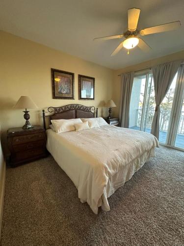 een slaapkamer met een bed en een plafondventilator bij Heron Lake in Orlando