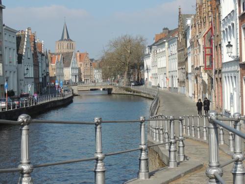 eine Brücke über einen Fluss in einer Stadt mit Gebäuden in der Unterkunft B&B Stoega in Brügge