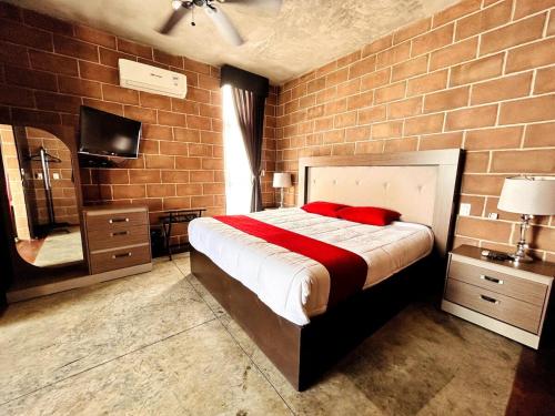 a bedroom with a large bed and a brick wall at Vistas Increíbles frente al mar by G P S rentas in Mazatlán