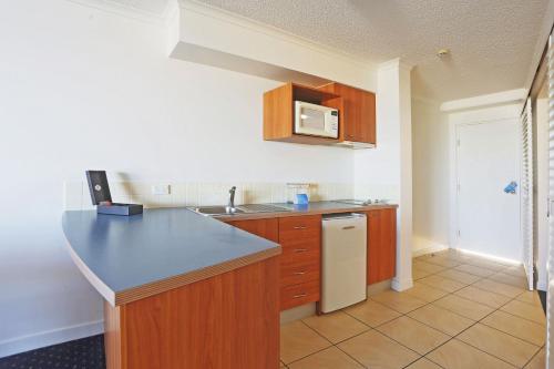 a kitchen with a counter and a sink and a microwave at Mantra Hervey Bay in Hervey Bay