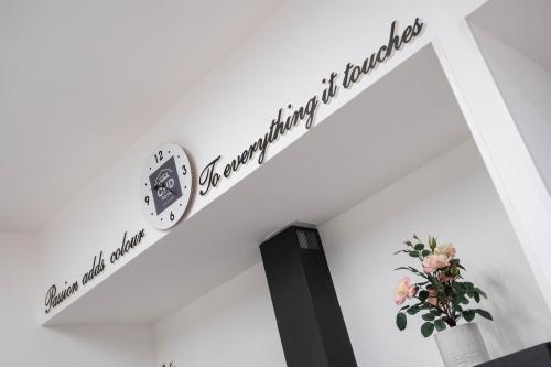a room with a white wall with a sign on it at CHD Rooms in Ancona