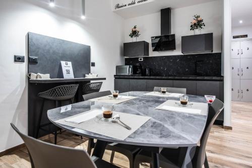 a dining room with a marble table and chairs at CHD Rooms in Ancona