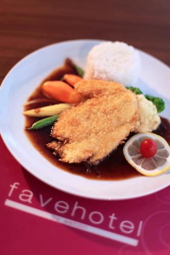a plate of food with chicken and vegetables and rice at favehotel Pekanbaru in Pekanbaru