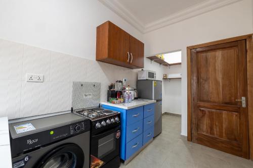 a kitchen with a stove and a washing machine at Caros villa luxury 2 bedroom in Adentan